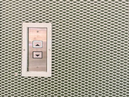 Closeup surface elevator button in up and down arrow sign on steel wall textured background with copy spaceの写真素材