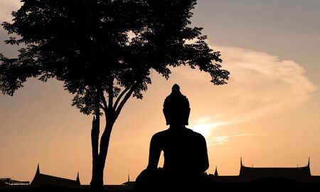 Silhouette,blurry,art tone of temple with big buddha statue with beautiful evening sky backgroundの写真素材