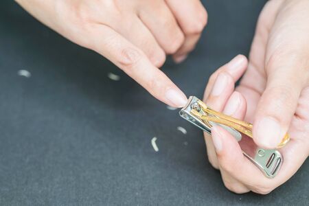 Woman cutting fingernails with nail scissorsの写真素材
