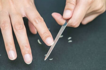 Woman using a nail file for nail careの写真素材