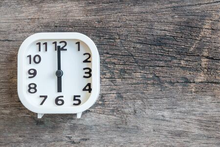 Closeup white clock for decorate in 6 o'clock on old wood floor textured background with copy spaceの写真素材