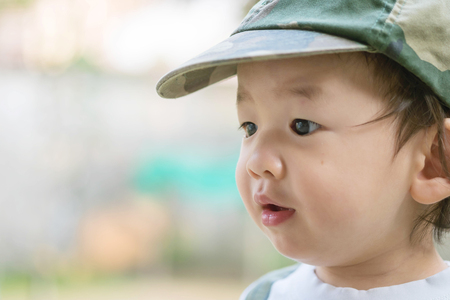 Closeup cute asian kid with interest in something emotion with copy spaceの写真素材