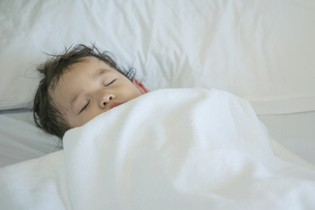 Closeup sick child sleep on hospital bed textured backgroundの写真素材