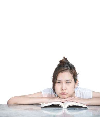 Closeup asian woman with boring face with a book on marble table in front of house isolated on white background with copy spaceの写真素材