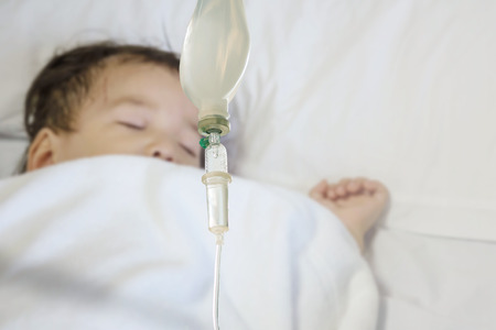 Closeup sick child sleep on hospital bed textured background with copy spaceの写真素材