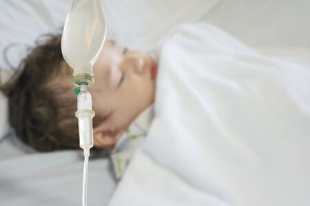 Closeup sick child sleep on hospital bed textured background with copy spaceの写真素材