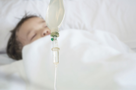 Closeup sick child sleep on hospital bed textured background with copy spaceの写真素材
