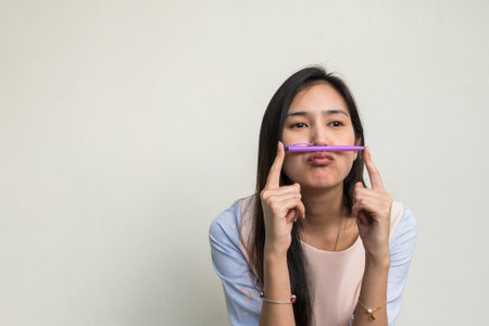 Cute asian woman on white wall background