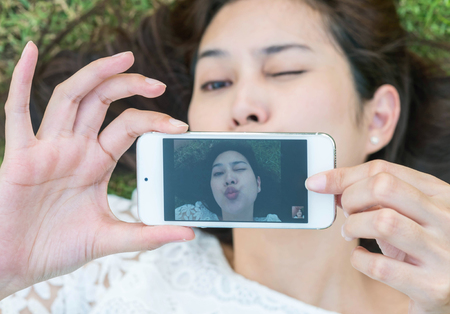 Closeup mobile on hand of woman with take a photo motionの写真素材
