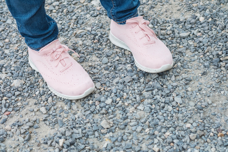 Closeup woman foot with pink shoe stand alone on floor textured backgroundの写真素材