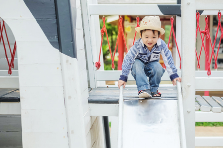Closeup asian kid play a slider at the playground backgroundの写真素材