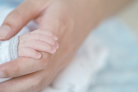 Closeup baby hand is holding the mother's hand with copy space