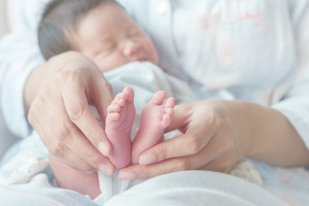 Closeup baby's foot with mother's hand