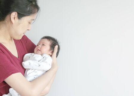 Closeup a baby girl in the mother's arms with copy spaceの写真素材