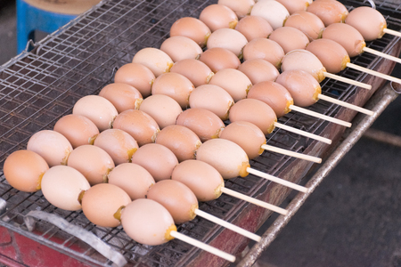 Grilled eggs on barbecue stove. Traditional Thai street food.の写真素材