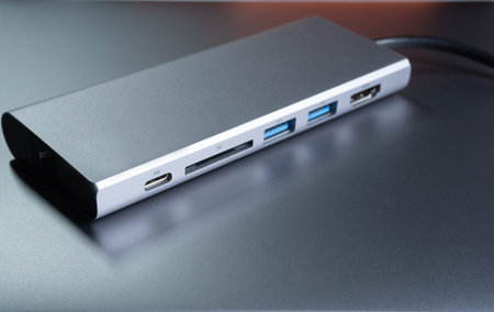 External hard drive with USB cable on gray background, close-up