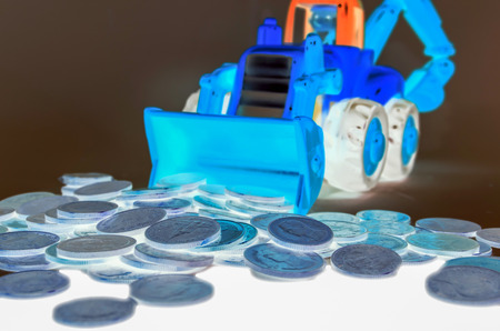 Backhoe digging and plow are coins. Isolate in black backgroundの写真素材