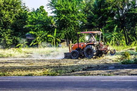 Tractor are plowing to adjust the area for football field and parking.の写真素材