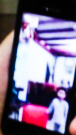 A woman talk face to face with his son at night by phone. Blurred abstract form.の写真素材