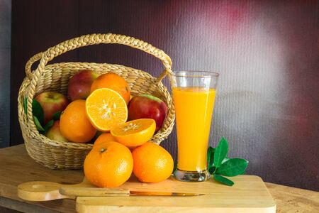 Fresh oranges and purple grape juice on the table./Bunch of Oranges  with water dropletsの写真素材