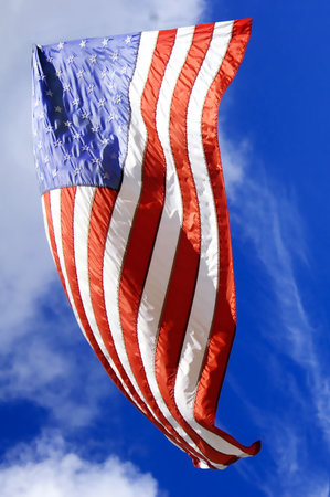 american flag in the wind on a blue sky 