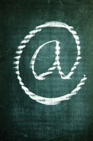 at sign written with a chalk on a blackboardの写真素材