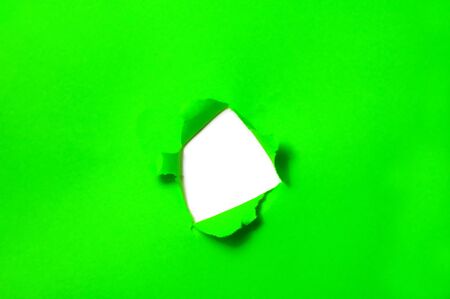 a hole on a green cardboard backgroundの写真素材