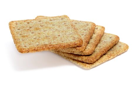 a pile of whole wheat flour crackers isolated on a white backgroundの写真素材