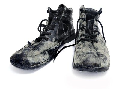 a pair of dirty black leather boots isolated on a white backgroundの写真素材