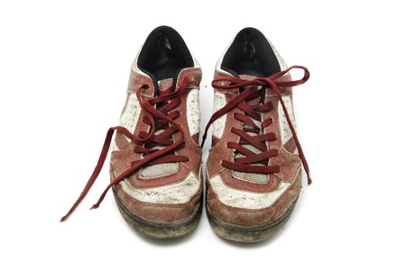 a pair of worn sneakers isolated on a white backgroundの写真素材