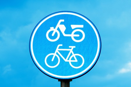 motorcycle and bicycle lane sign over the skyの写真素材