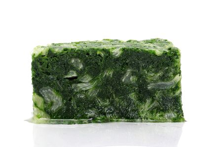 a block of frozen spinach isolated on a white backgroundの写真素材