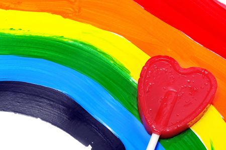 a lollipop heart-shapped over a rainbow flag paintedの写真素材