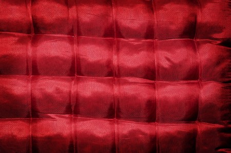 closeup of a red satin cushioned textileの写真素材