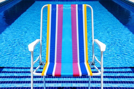 a deckchair in a swimming pool in the summerの写真素材