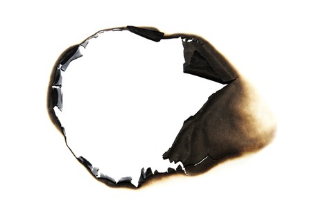 burned hole on a white paper backgroundの写真素材