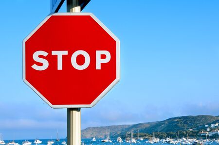 an stop traffic sign in a road on the coastの写真素材