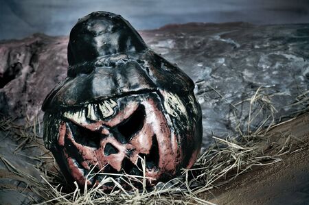 closeup of a jack-o'-lantern in a cemetery for Halloweenの写真素材