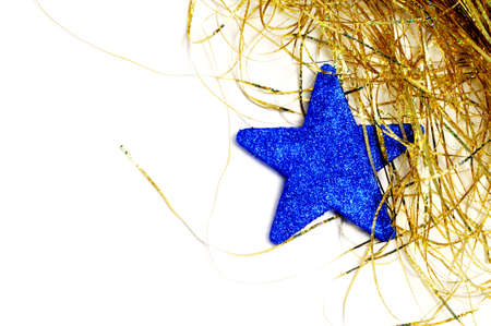 a blue christmas star and golden tinsel on a white background の写真素材