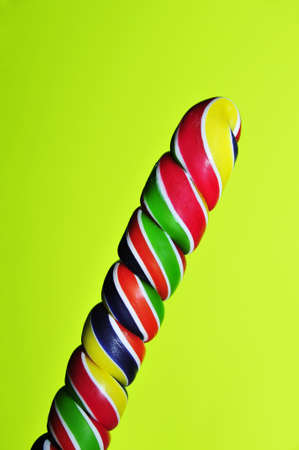 a rainbow lollipop on a green backgroundの写真素材