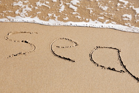 word sea written on the sand of a beachの写真素材