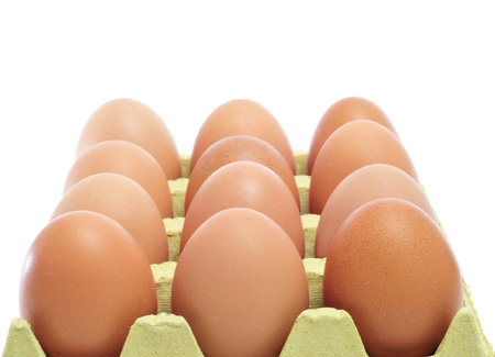 closeup of a pile of brown eggs in an egg carton