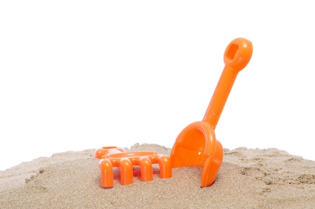 a beach shovel and a beach rake on the sand on a white backgroundの写真素材