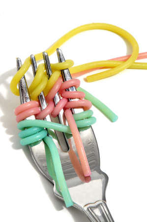 some vegetable spaghetti rolled in a fork on a white backgroundの写真素材