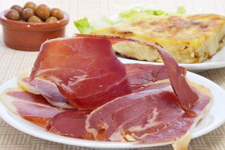 some spanish tapas, as tortilla de patatas, serrano ham and olivesの写真素材