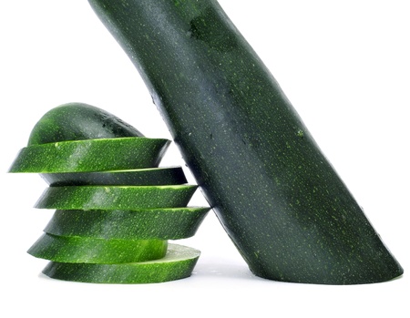 a cucumber cut in slices on a white backgroundの写真素材