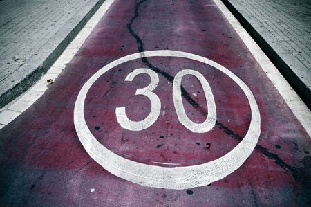 a speed limit sign painted on the roadの写真素材