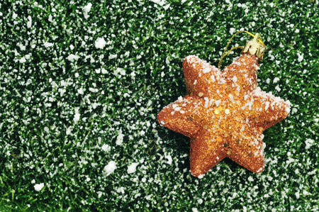 a golden christmas star on the grass with snow