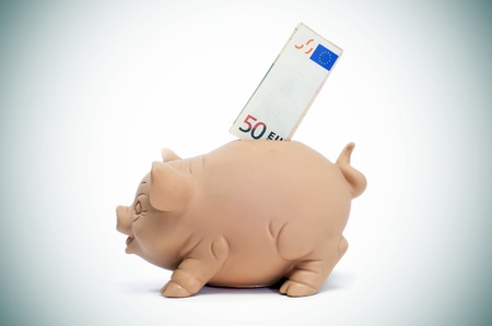 a 50 euro bill in a piggy bankの写真素材