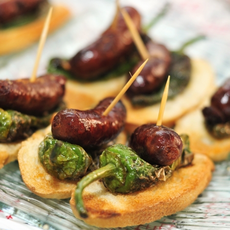 closeup of a plate with spanish pinchos made with chorizos an Padron peppersの写真素材